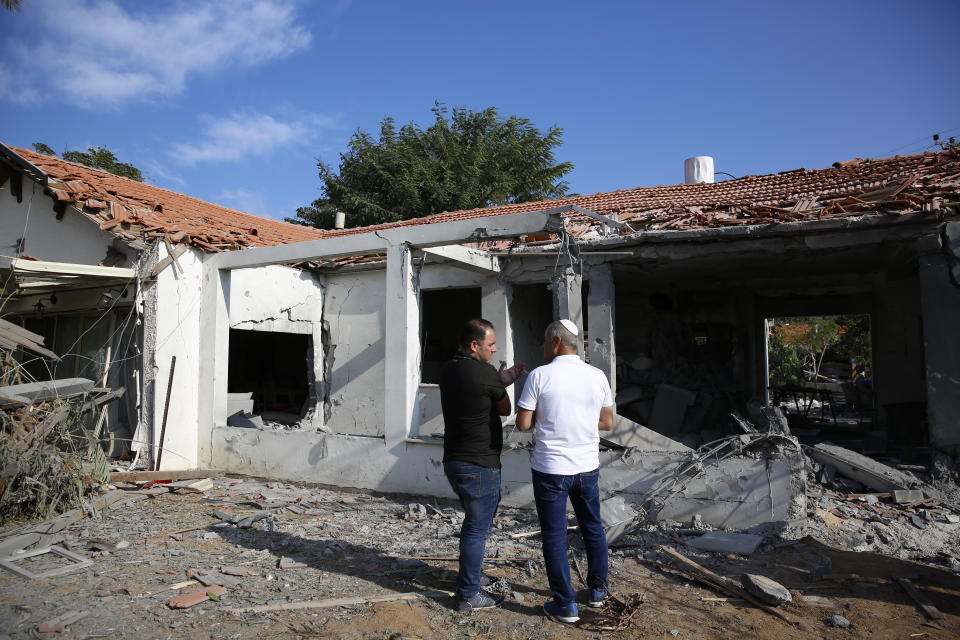 Officials assess the damage to a house after it was hit by a rocket fired by Palestinian militants from the Gaza Strip, in the southern Israeli city of Ashkelon, Israel, Tuesday, Nov. 13, 2018. (AP Photo/Ariel Schalit)