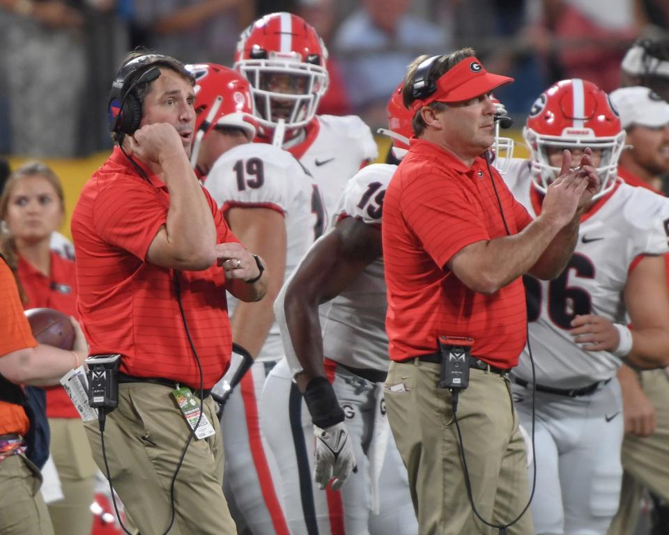 Georgia assistant Will Muschamp, left, signals a play near Georgia Head Football Coach Kirby Smart during the first quarter of the Duke's Mayo Classic Sep 4, 2021; Charlotte, North Carolina, USA;  at Bank of America Stadium. (Ken Ruinard-USA TODAY Sports)