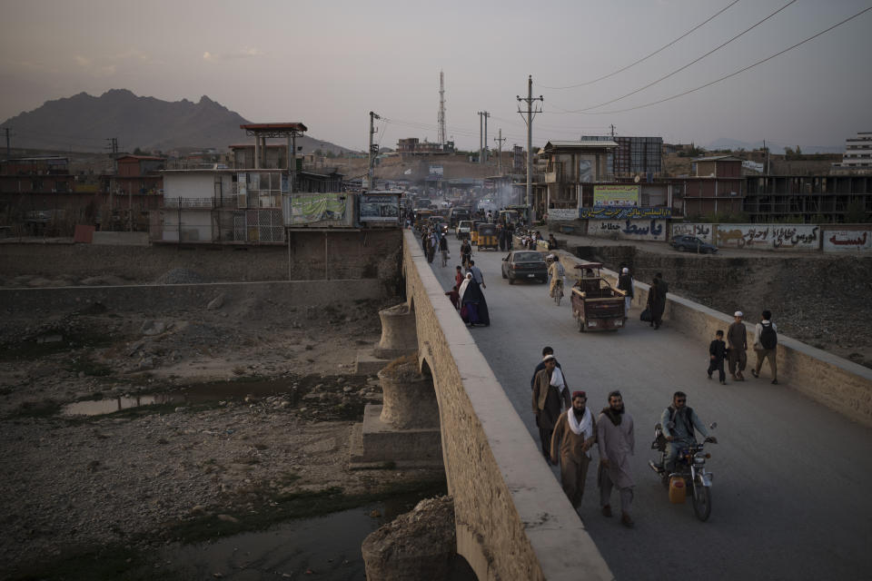 Afghans cross a bridge above the Kabul river in Kabul, Afghanistan, Tuesday, Sept. 28, 2021. (AP Photo/Felipe Dana)