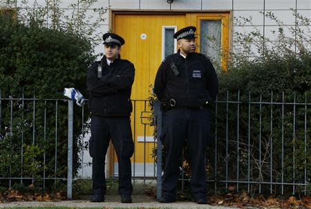 Police stand guard in front of a property in Lambeth, south London November 23, 2013. REUTERS/Luke MacGregor