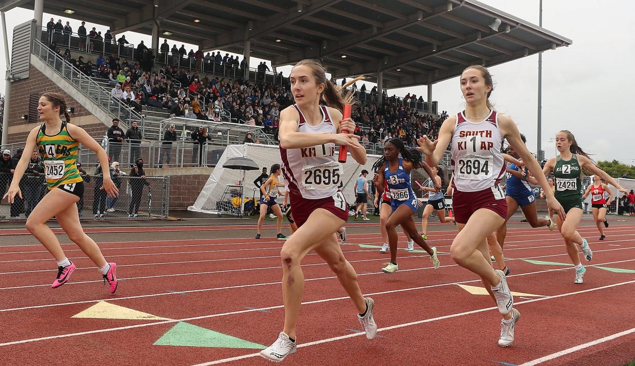 South Kitsap's Ella Hopper takes the baton from her sister Elise as they compete in the 4x200 meter relay during the State Track and Field Championships at Mount Tahoma High School on Saturday, May 28, 2022.
