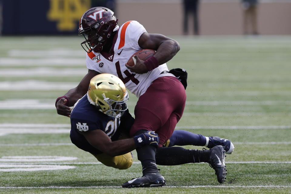 Virginia Tech quarterback Quincy Patterson II (4) is tackled by Notre Dame cornerback Shaun Crawford (20) during the first half of an NCAA college football game, Saturday, Nov. 2, 2019, in South Bend, Ind. (AP Photo/Carlos Osorio)