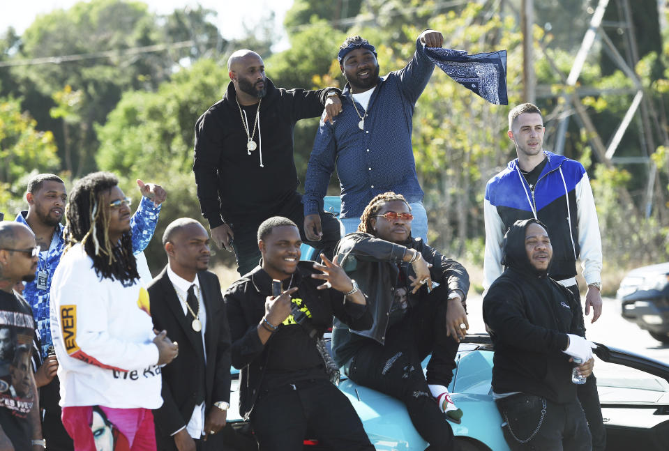 Attendees of a burial service for the late rapper Nipsey Hussle stage to tribute to him before they leave the Forest Lawn Hollywood Hills cemetery, Friday, April 12, 2019 in Los Angeles. (Photo by Chris Pizzello/Invision/AP)