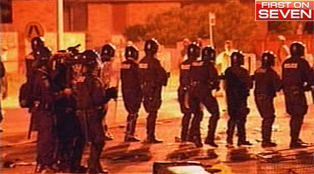 Sydney police officers line the street during the Macquarie Fields riots in February 2005. Photo: 7News