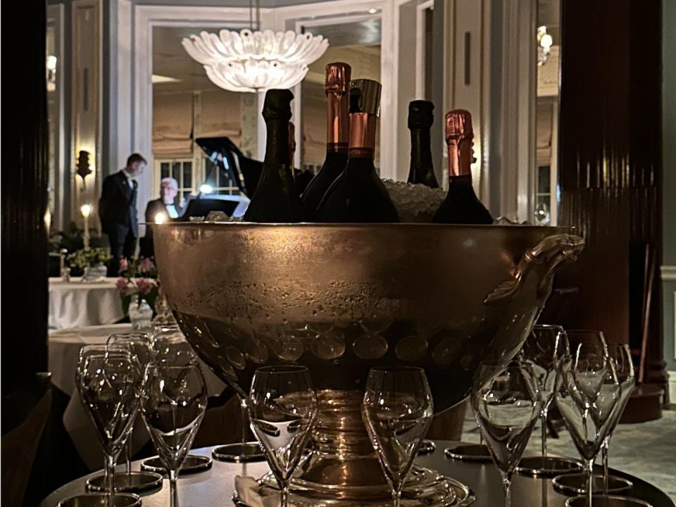 A front view of a champagne bucket with glasses dotted around the edge