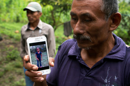 Domingo Caal, 61, grandfather of Jakelin, a 7-year-old girl who died in U.S. custody, holds his mobile phone with a picture of his granddaughter as he stands outside her house in Raxruha, Guatemala December 15, 2018. REUTERS/Josue Decavele