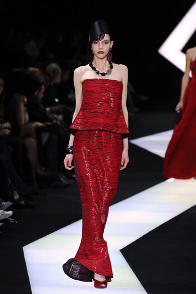 Giorgio Armani Privé hat bei diesem Kleid eine ziemlich interessante Silhouette gezaubert, da die Taille nicht betont wird. Bei genauerem Hingucken sieht man erst, dass die Robe nicht einfach nur Rot ist, sondern dass viele feine, rote Streifen auf transparenten, schwarzen Stoff applliziert wurden.