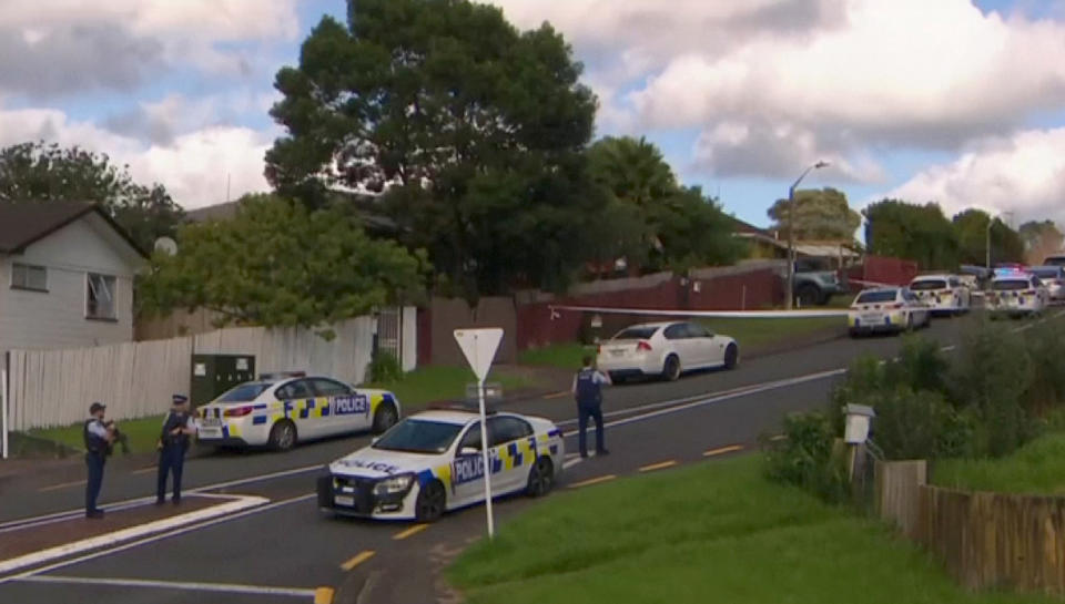 This image made from a video, shows armed police at the scene of a shooting incident following a routine traffic stop in Auckland, New Zealand, Friday, June 19, 2020. New Zealand police say a few officers have been shot and seriously injured and a suspect is on the run. (TV New Zealand via AP)