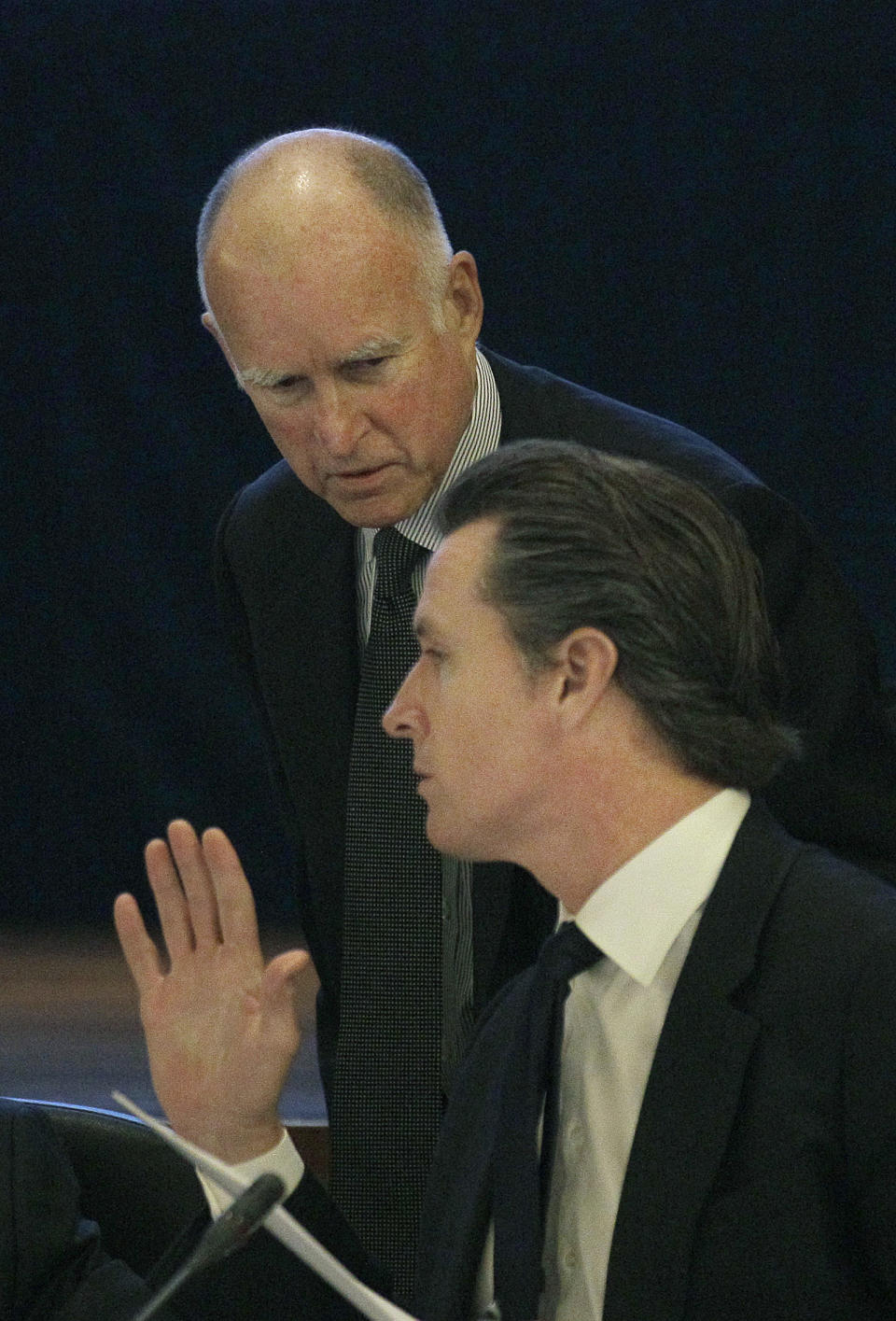 Gov. Jerry Brown, left, talks with Lt. Gov. Gavin Newsom at the UC Board of Regents meeting in San Francisco, Wednesday, Nov. 14, 2012. Brown is set to make his first appearance where he's expected to urge UC officials to control costs and avoid raising tuition. (AP Photo/Jeff Chiu)