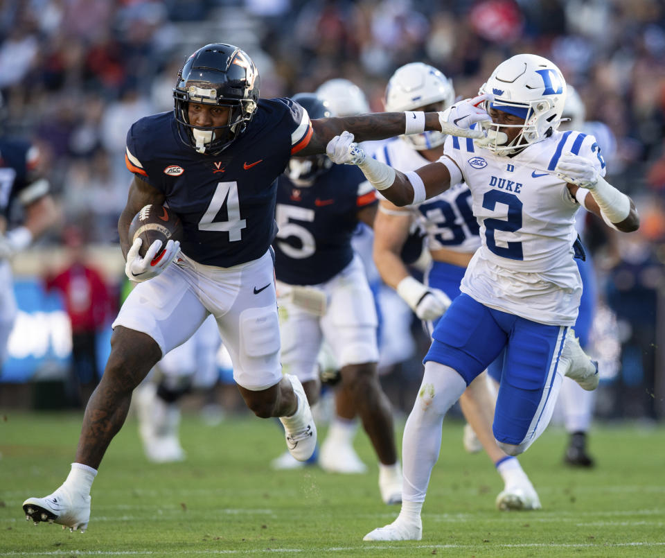 Virginia wide receiver Malik Washington (4) stiff-arms Duke safety Jaylen Stinson (2) during the first half of an NCAA college football game Saturday, Nov. 18, 2023, in Charlottesville, Va. (AP Photo/Mike Caudill)