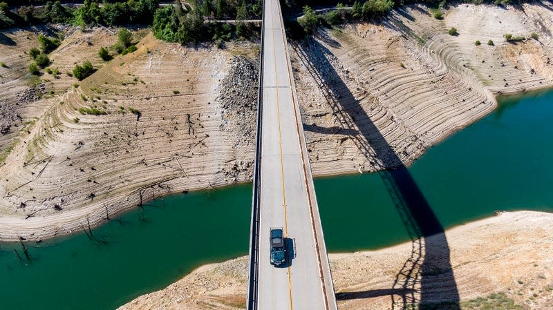 A car crosses Enterprise Bridge over Lake Oroville’s dry banks on May 23, 2021, in Oroville, California. 