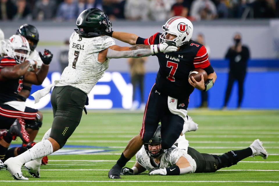 Utah quarterback Cameron Rising throws a stiff-arm at  Oregon linebacker Noah Sewell during the Pac-12 Conference championship game on Dec. 3 in Las Vegas.