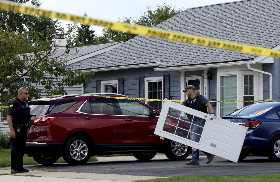 A Romeoville Police officer carries out a door from inside of the home where four people were shot to death, on Monday, Sept. 18, 2023, in Romeoville Ill. (Stacey Wescott/Chicago Tribune via AP)