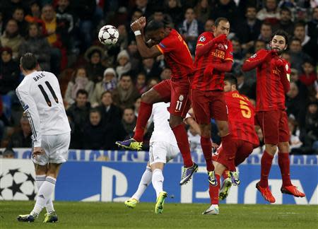 Real Madrid's Gareth Bale (L) kicks the ball to score a goal against Galatasaray during their Champions League soccer match at Santiago Bernabeu stadium in Madrid November 27, 2013. REUTERS/Juan Medina