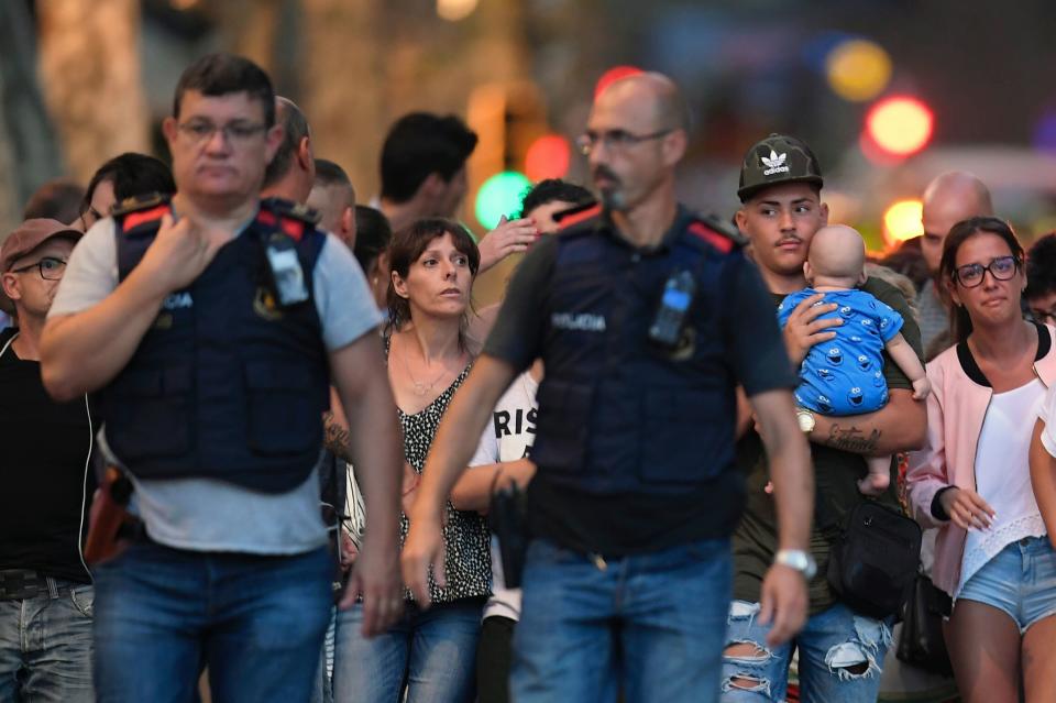 Spanish policemen accompany people leaving the cordoned off area.&nbsp;