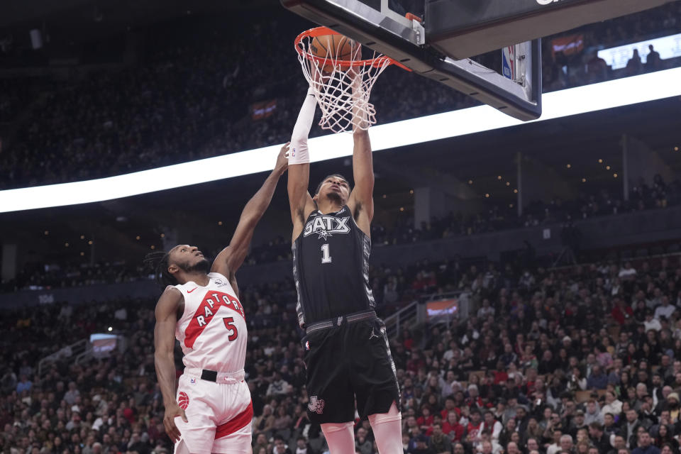 San Antonio Spurs center Victor Wembanyama (1) dunks as Toronto Raptors guard Immanuel Quickley (5) defends during first-half NBA basketball game action in Toronto, Monday Feb. 12, 2024. (Chris Young/The Canadian Press via AP)
