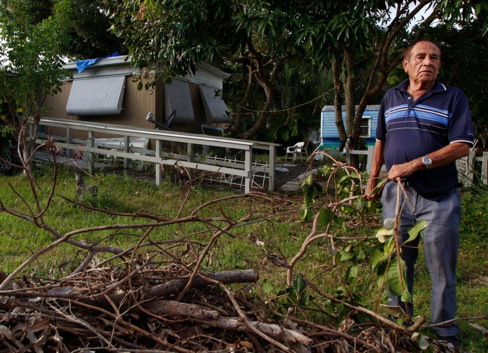 Francisco Flores, who has lived in Citrus Park Village for 20 years with his wife, picks up yard debris from Hurricane Ian on Tuesday, Oct. 4, 2022, outside his home. With plans to move home to El Salvador if the park evicts them, he says he plans to leave his mobile home where it has stood for the duration of his time in the park. "It's too expensive, and I do not have anywhere to take it," he said. Sometimes, Flores said, they stay at his daughters home 3 blocks down the road, but his wife, who has Alzheimer's, prefers to stay where she feels the familiarity of home. "My daughter told us to not live here anymore because it is going to be taken down, but my wife wants to be here."