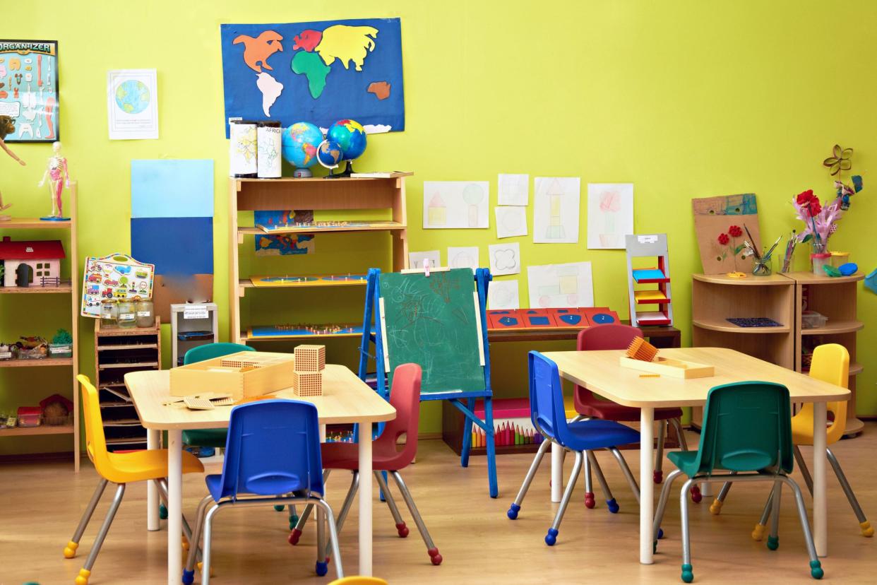 colorful classroom with square tables with four chairs each