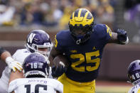 Michigan running back Hassan Haskins (25) rushes during the first half of an NCAA college football game against Northwestern, Saturday, Oct. 23, 2021, in Ann Arbor, Mich. (AP Photo/Carlos Osorio)