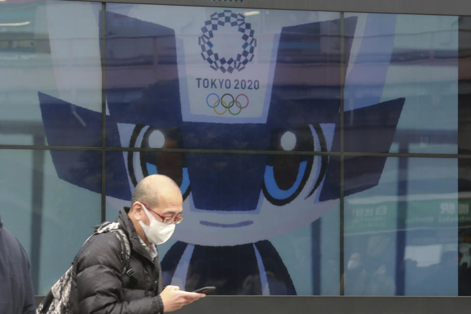 A man walks by an electric monitor promoting the Tokyo 2020 Olympics planned to start in the summer of 2021, in Tokyo, Wednesday, Jan. 27, 2021. (AP Photo/Koji Sasahara)