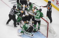 Dallas Stars goalie Anton Khudobin (35) covers the puck as players scuffle next to him during the third period against the Vegas Golden Knights of Game 4 of the NHL hockey Western Conference final, Saturday, Sept. 12, 2020, in Edmonton, Alberta. (Jason Franson/The Canadian Press via AP)