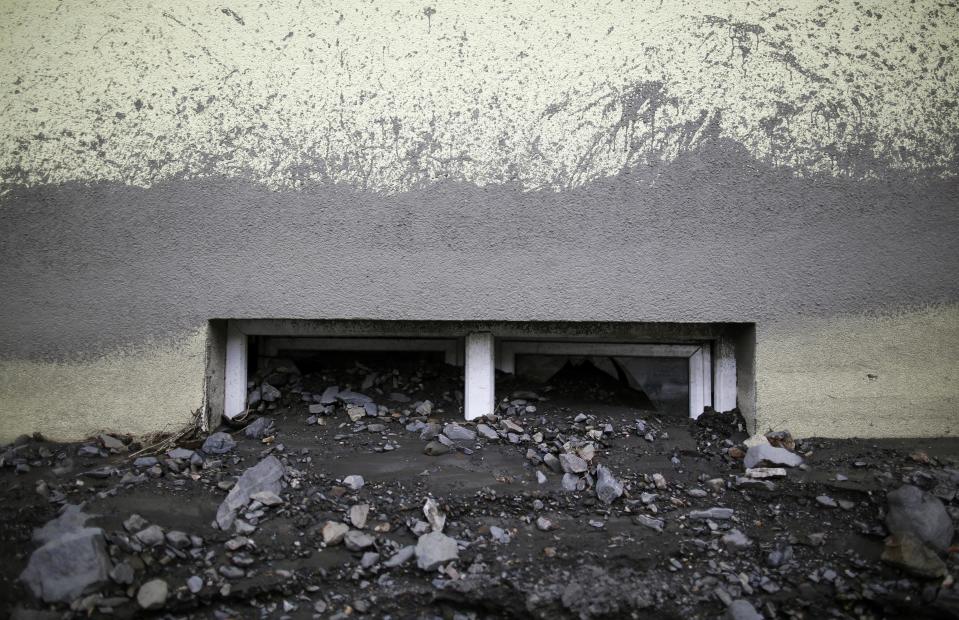 Debris from floods are seen through the window of a flood-damaged house in Topcic Polje