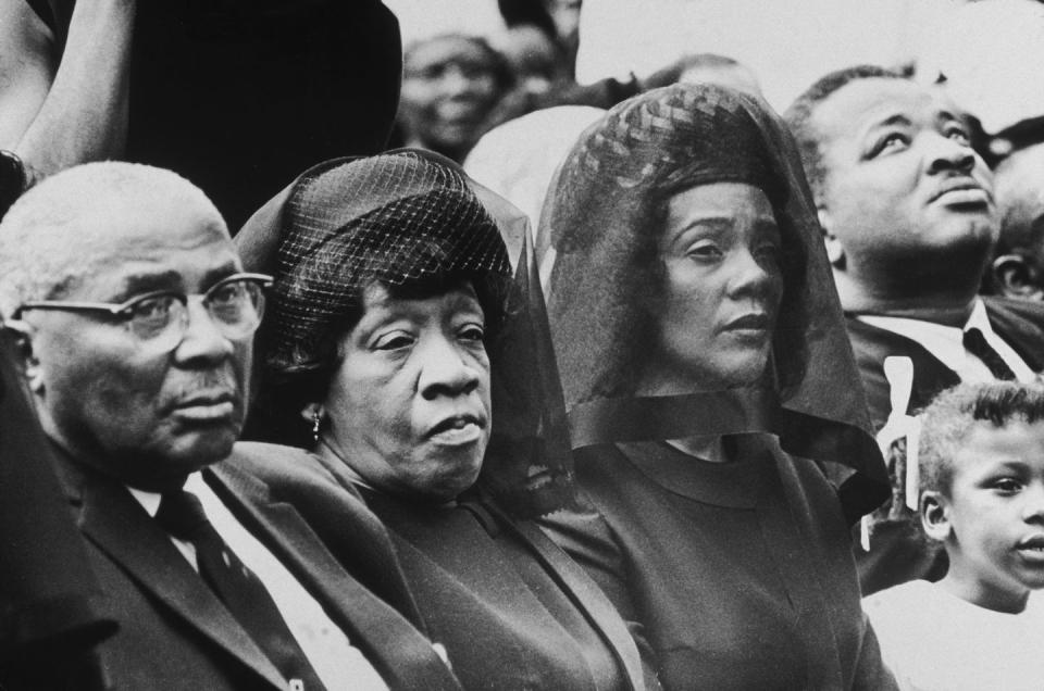 martin luther king sr and alberta king sit and look right, they were formal attire, martin sr wears glasses, alberta wears a hat with netting and a veil