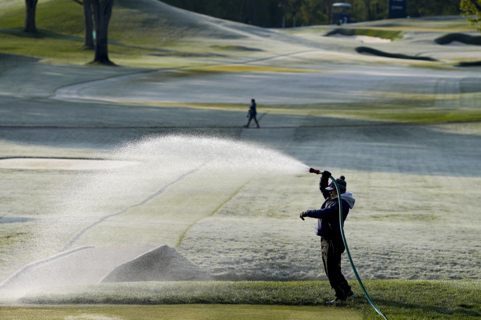 A grounds keeper prepares the course during during a frost delay before the first round of the PGA Championship golf tournament at Oak Hill Country Club on Thursday, May 18, 2023, in Pittsford, N.Y. (AP Photo/Seth Wenig)