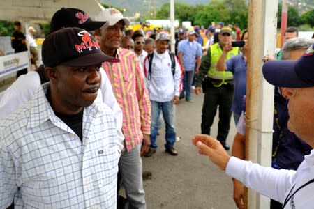 Colombian migration officer speaks Colombian citizens at the Simon Bolivar International Bridge