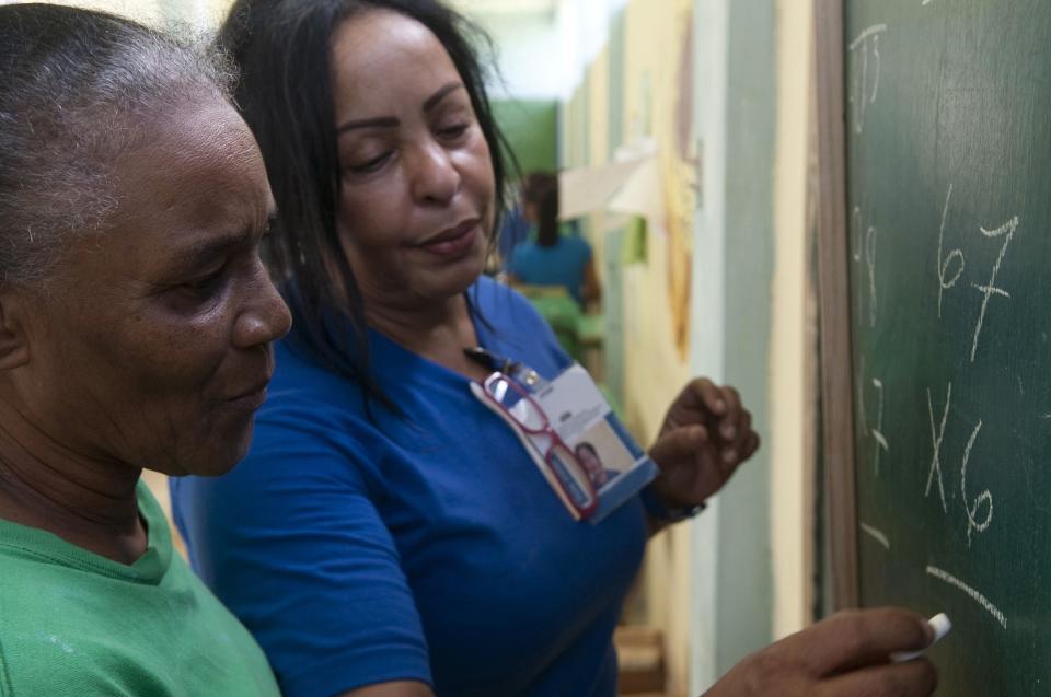 A prisoner studies maths with a teacher inside the renovated wing of the Najayo women's prison in San Cristobal