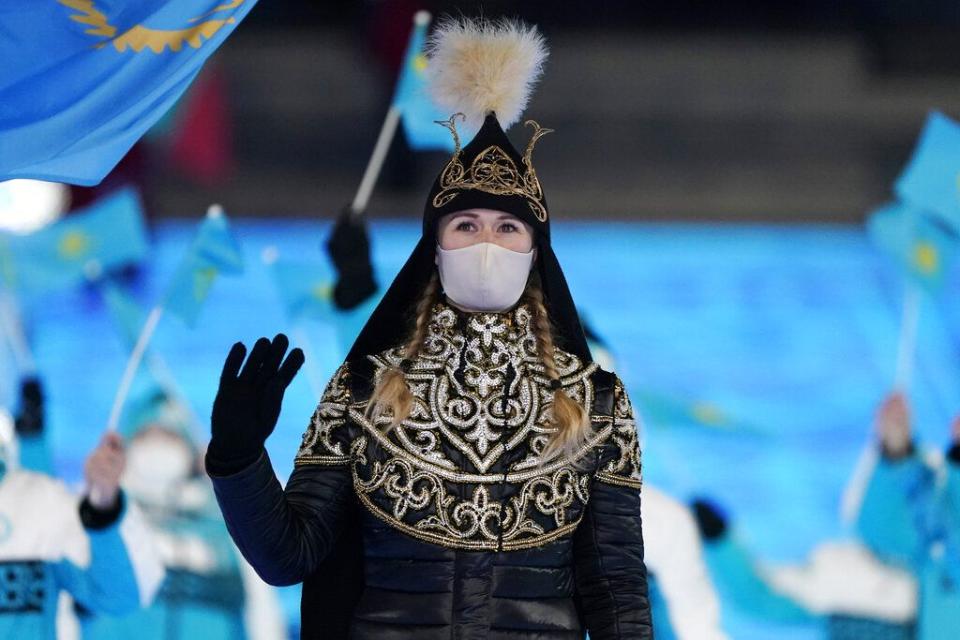 Yekaterina Aidova, of Kazakhstan, waves as she walks into the stadium during the opening ceremony of the 2022 Winter Olympics, Friday, Feb. 4, 2022, in Beijing. (AP Photo/Jae C. Hong)