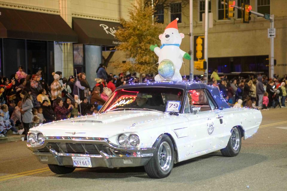 Decked out in Christmas lights a classic Ford Thunderbird rolls past the crowd on Polk Street  Friday night during the Center City Electric Light Parade in downtown Amarillo.