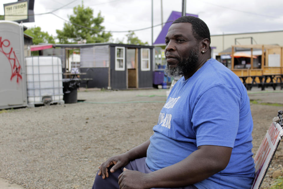 Carl Baskin sits by his car wash business in Portland, Ore., as he discusses protests that have been unfolding nightly in this historically Black neighborhood on Wednesday, July 1, 2020. Thousands of protesters in the liberal and predominantly white city have taken to the streets peacefully every day for more than five weeks to decry police brutality, but recent violence by smaller groups is creating a deep schism in the protest movement. As demonstrations enter their second month, they have shifted to a historically Black neighborhood. (AP Photo/Gillian Flaccus)