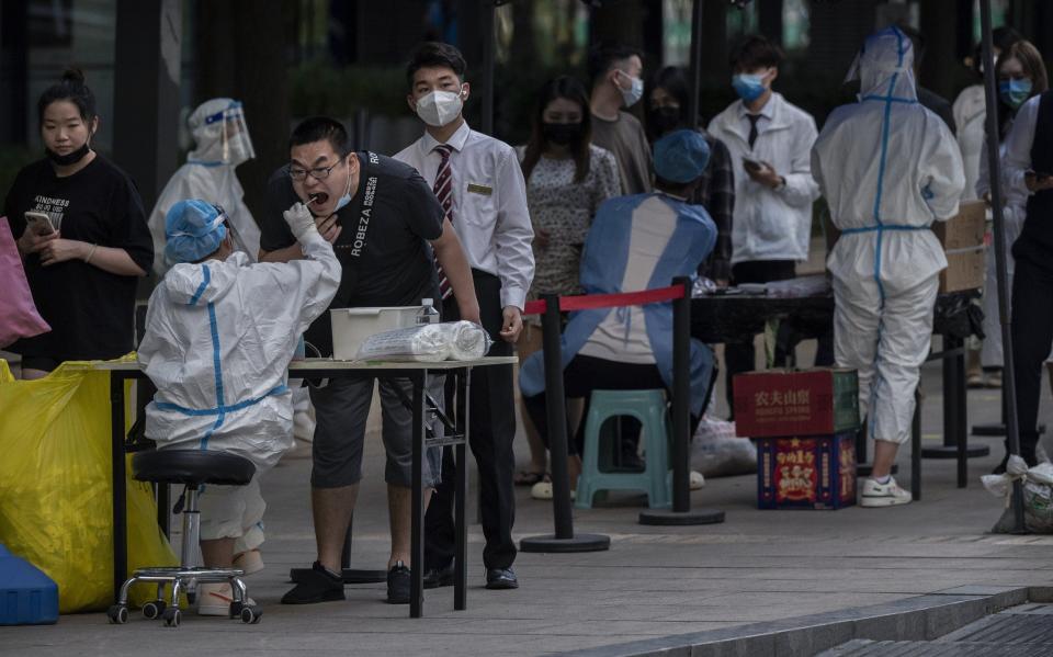 A health worker waits to perform nucleic acid tests at a testing site after a recent Covid-19 outbreak in Beijing - Kevin Frayer/Getty Images