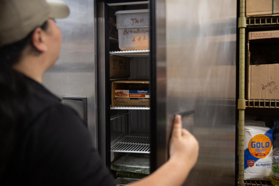 Joanie Garza, a public health inspector with the city, looks inside of a refrigerator during a restaurant inspection on June, 6 2023, in Corpus Christi, Texas.