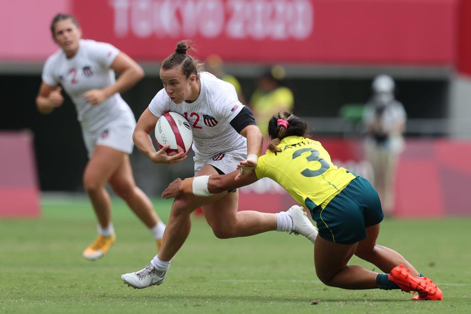 Kristi Kirshe (middle) evades a tackle by Australia's Faith Nathan on day 2 of the Tokyo 2020 Olympic Games at Tokyo Stadium on 30 July, 2021 in Tokyo, Japan.