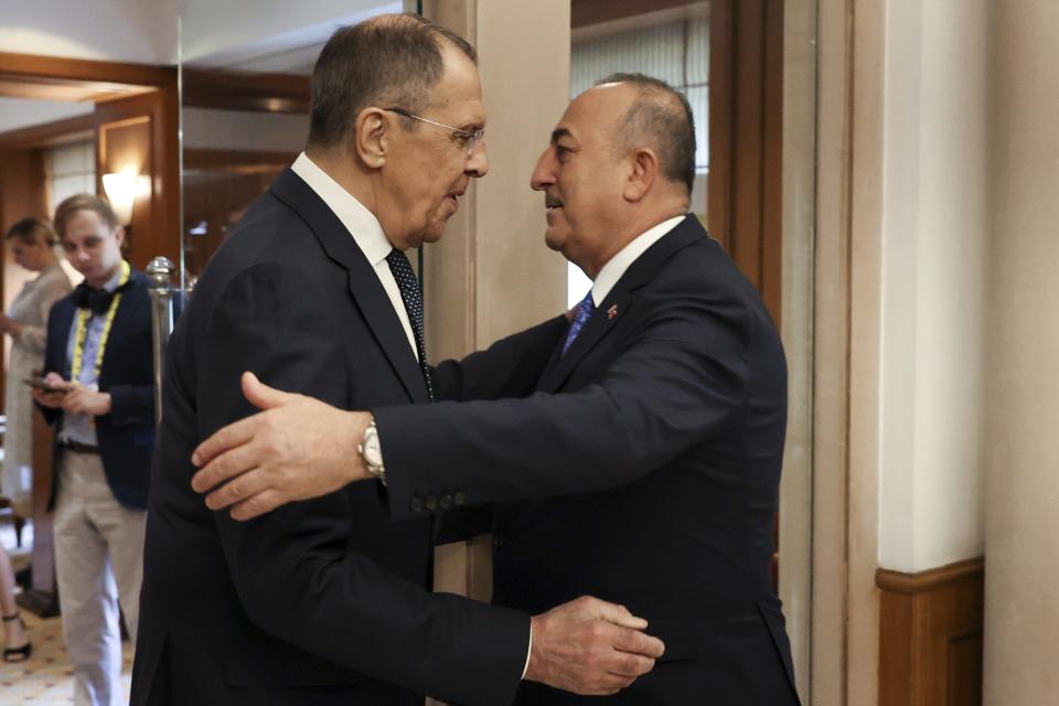 In this handout photo released by Russian Foreign Ministry Press Service, Russian Foreign Minister Sergey Lavrov, left, and Turkish Foreign Minister Mevlut Cavusoglu greet each other during their meeting on the sideline of G20 foreign minister's meeting in New Delhi, India, Wednesday, March 1, 2023. (Russian Foreign Ministry Press Service via AP)