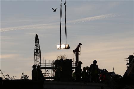 Rescue workers lift a rotor blade from the site of a police helicopter crash onto the Clutha Pub in central Glasgow, Scotland, December 1, 2013. REUTERS/Andrew Winning