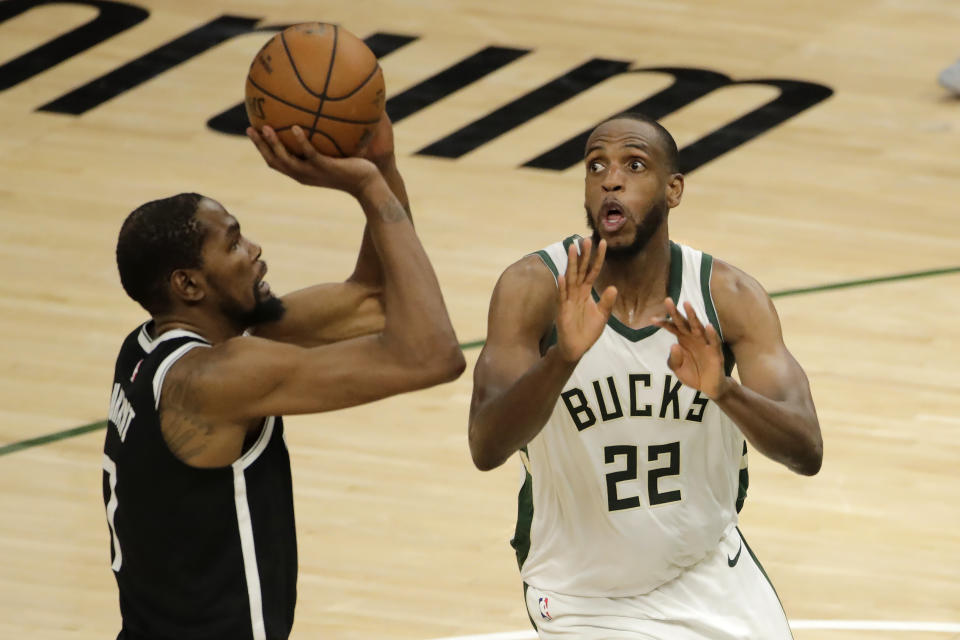 Brooklyn Nets' Kevin Durant, left, shoots against Milwaukee Bucks' Khris Middleton, right, during the second half of an NBA basketball game Tuesday, May 4, 2021, in Milwaukee. (AP Photo/Aaron Gash)