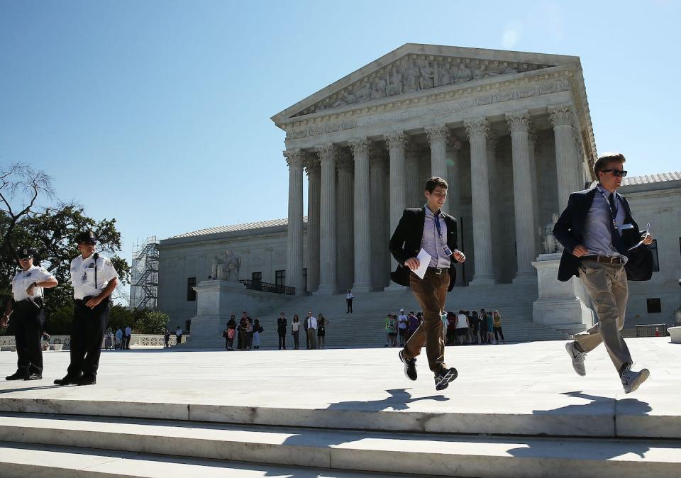 Two interns run with a newly released Supreme Court ruling in June 2016 in Washington. <a href="https://media.gettyimages.com/id/541738758/photo/supreme-court-prepares-to-hand-down-opinions-on-landmark-cases.jpg?s=1024x1024&w=gi&k=20&c=y7RLNmF201ZkZfZfZuOEMS4Oxp5m7YEzifu6XkVjKdM=" rel="nofollow noopener" target="_blank" data-ylk="slk:Mark Wilson/Getty Images;elm:context_link;itc:0;sec:content-canvas" class="link ">Mark Wilson/Getty Images</a>