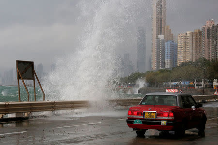 A taxi drives past a big wave on a waterfront as Typhoon Haima approaches in Hong Kong, China, October 21, 2016 . REUTERS/Bobby Yip