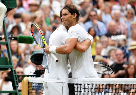 Tennis - Wimbledon - All England Lawn Tennis and Croquet Club, London, Britain - July 14, 2018. Spain's Rafael Nadal embraces Serbia's Novak Djokovic after Djokovic won their semi final match. REUTERS/Toby Melville