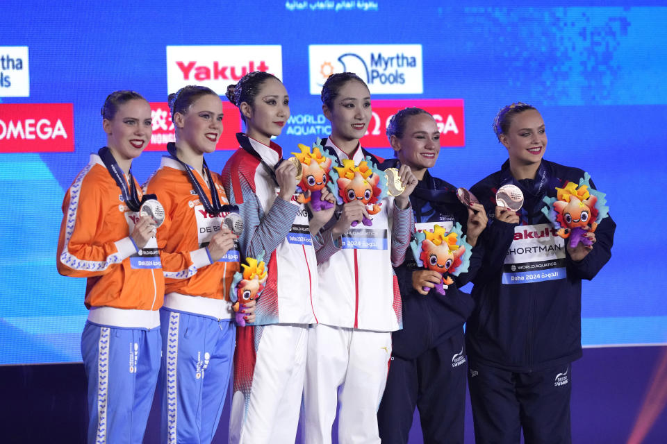 Gold medalists Wang Liuyi and Wang Qianyi, of China, center, silver medalists Bregje de Brouwer and Noortje de Brouwer, of the Netherlands, and bronze medalists Kate Shortman and Isabelle Thorpe, of Great Britain pose for a photo during the medal ceremony for the women's duet free final of artistic swimming at the World Aquatics Championships in Doha, Qatar, Thursday, Feb. 8, 2024. (AP Photo/Lee Jin-man)