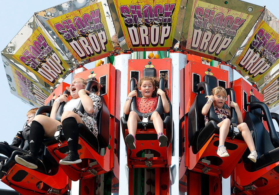Emilin Goodrich, left, Addilynn Krites and Daphne Canter react as the Shock Drop ride drops from the top point of the ride at the 2021 Wayne County Fair in Wooster.