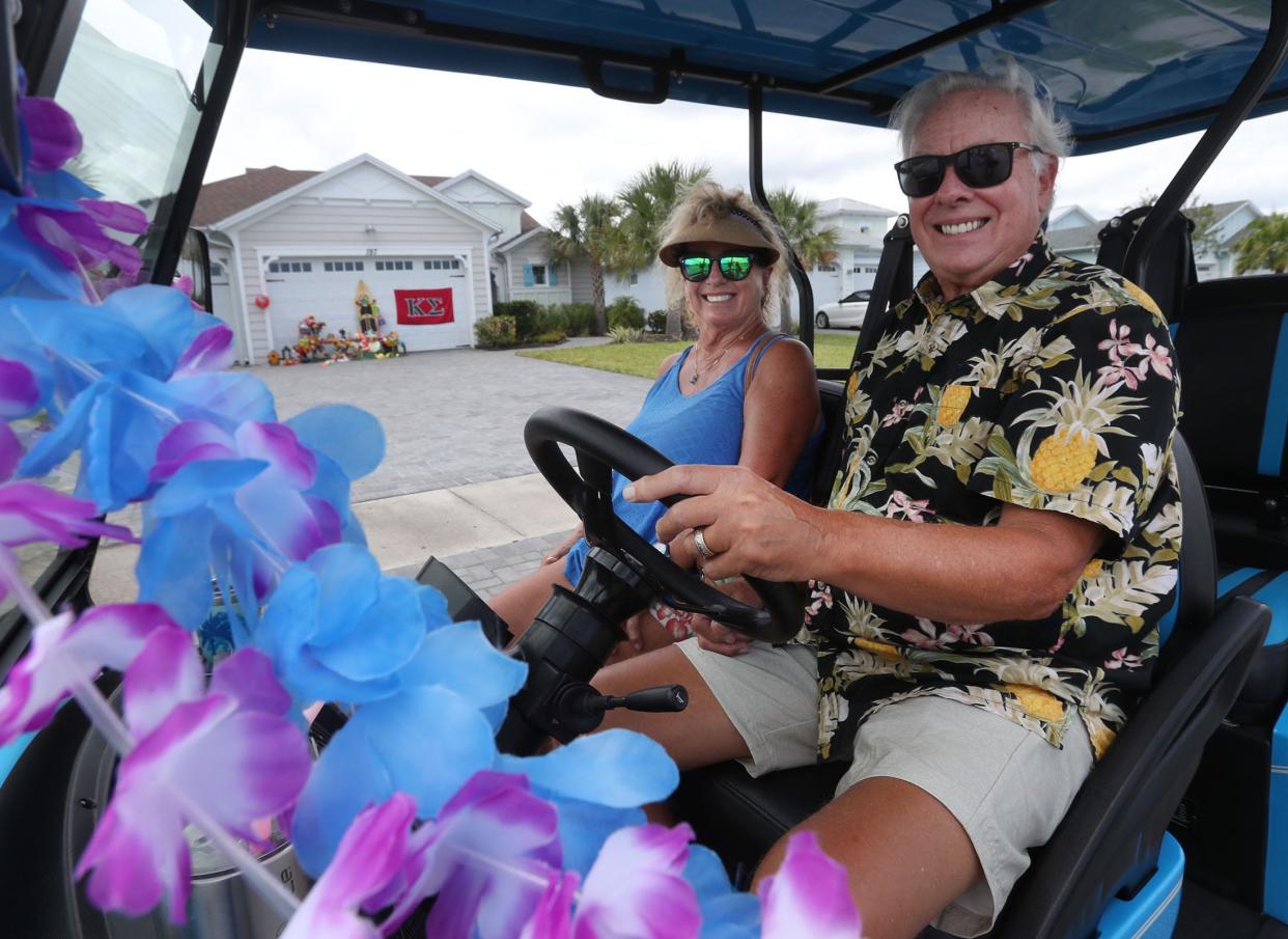 Latitude Margaritaville residents Laurie and Bruce Savolainen check out the house owned by the late Jimmy Buffett at 197 Island Breeze Ave., Daytona Beach, Tuesday, Sept. 5, 2023. Residents at the 55-plus community  created a makeshift memorial in front of the garage following the 76-year-old singer-songwriter's death on Sept. 1.