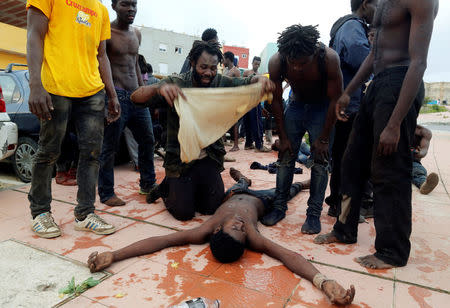 An African migrant gets fanned on the ground after crossing a border fence between Morocco and Spain's north African enclave of Ceuta October 31, 2016. REUTERS/M. Martin