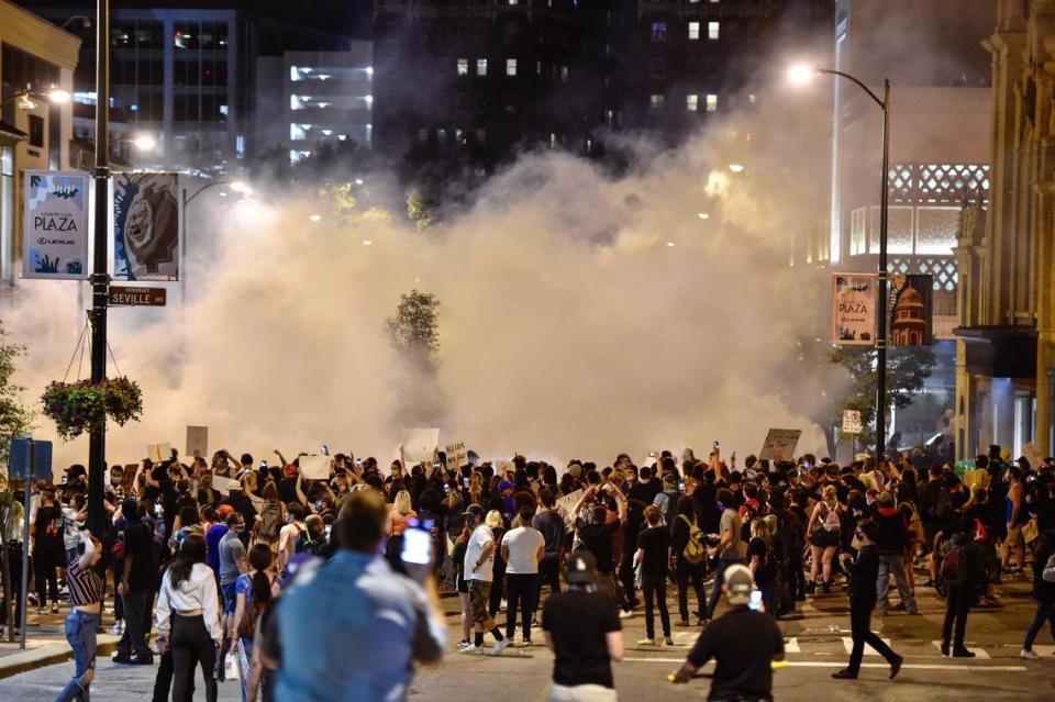 A cloud of tear gas covers a crowd of protesters at the Country Club Plaza Saturday, May 30, 2020. The large group of protesters were there to bring awareness to the death of George Floyd who died while in the custody of Minneapolis police.