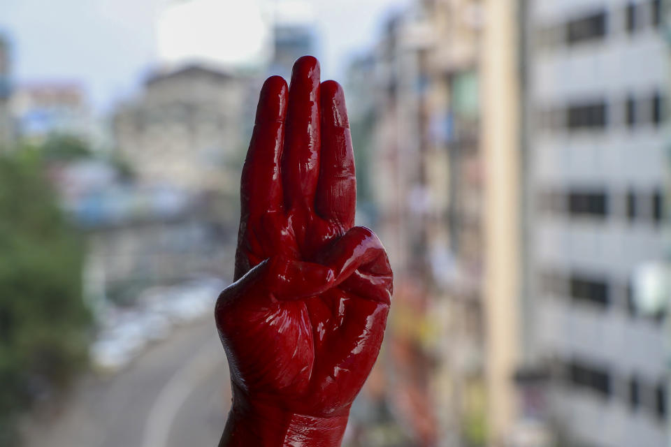 An anti-coup protester shows the three fingered salute of resistance on his red painted hand in memory of protesters who lost their lives during previous demonstrations in Yangon, Myanmar on Tuesday, April 6, 2021. Threats of lethal violence and arrests of protesters have failed to suppress daily demonstrations across Myanmar demanding the military step down and reinstate the democratically elected government. (AP Photo)