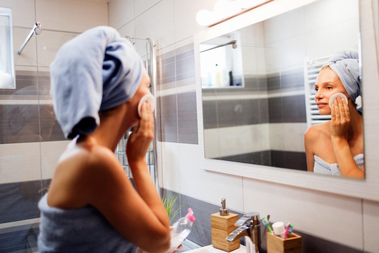 woman cleaning her skin in bathroom