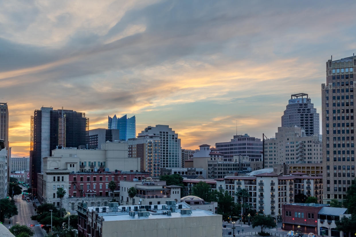 A photo featuring the San Antonio skyline against a dramatic sunset